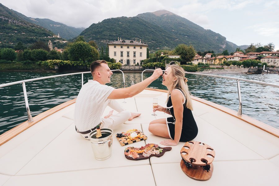A Boy Feeds His Girlfriend On The Boat In Front Of Villa Balbiano after wedding proposal