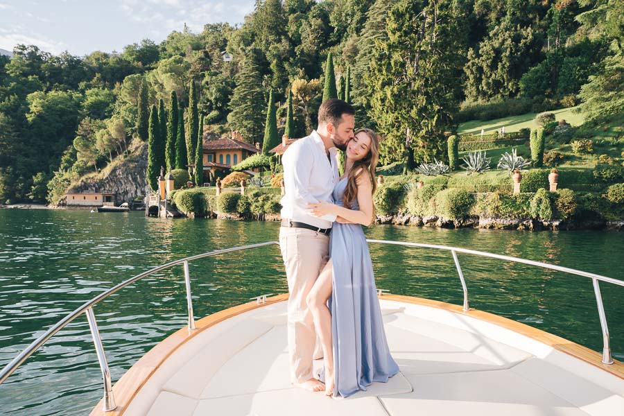 a guy kiss on the cheek his girlfriend on a boat in lake como in front of villa cassinella