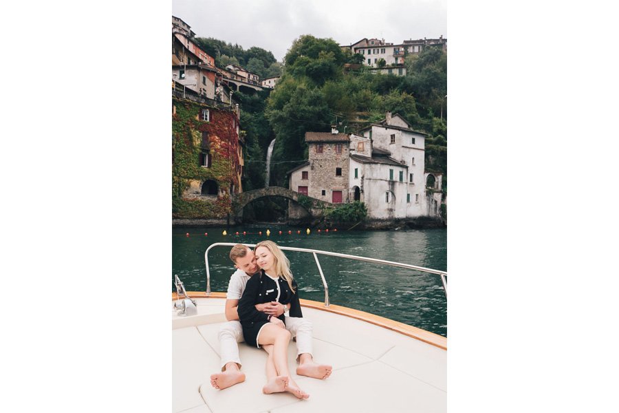A Newly Engaged Couple Tenderly Embrace Each Other On The Boat At The Orrido Di Nesso
