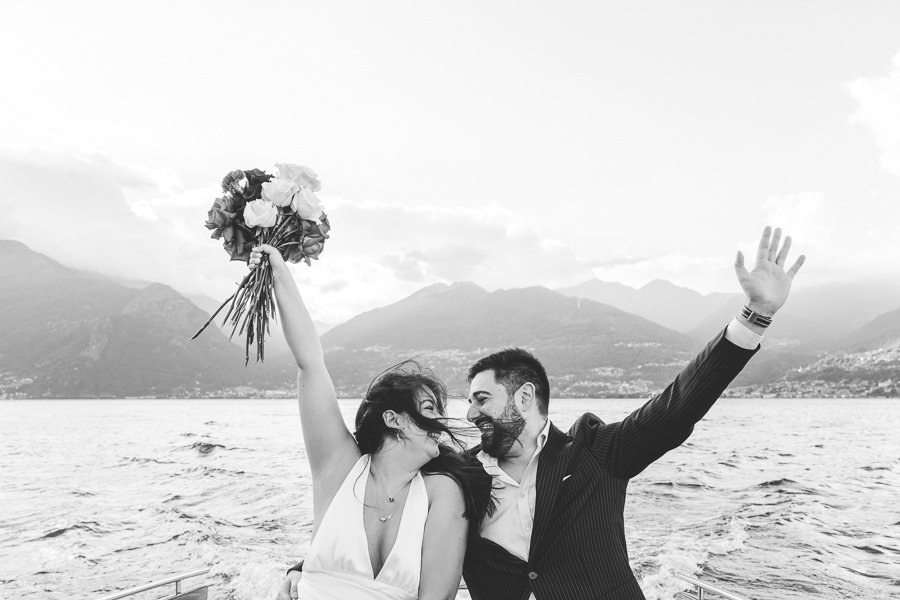 Happy Couple On Boat With Bouquet On Lake Como during surprise proposal shooting