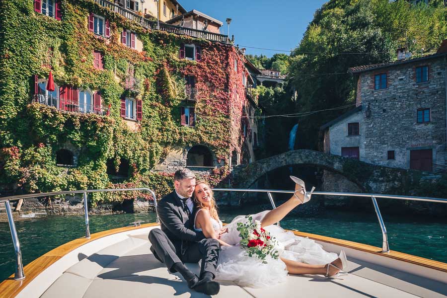Newlyweds they hug And Smile On A Boat In Front Of Orrido Di Nesso