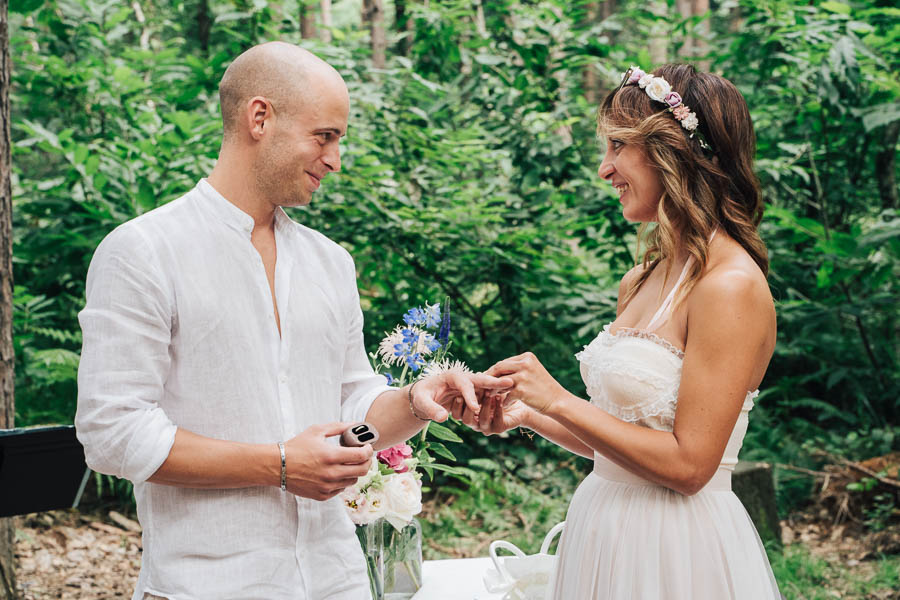The Bride And Groom Exchange Rings In The Woods