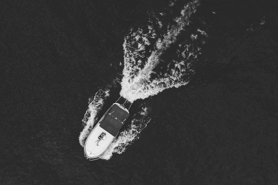 Two Boys In Love Kiss On The Boat While Sailing On Lake Como during proposal photo session